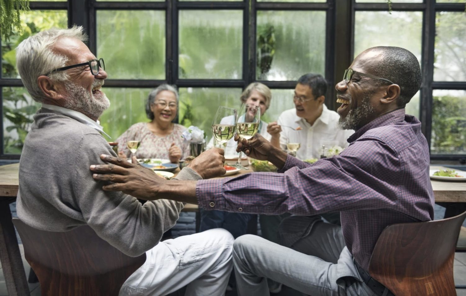 A group of seniors in St. Louis, MO share conversion and laughter over dinner thanks to their hearing aids.